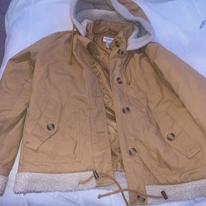 Beige jacket for the fall/winter with fur on both sleeves and hood.